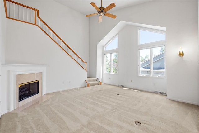 unfurnished living room with high vaulted ceiling, carpet floors, stairs, and visible vents