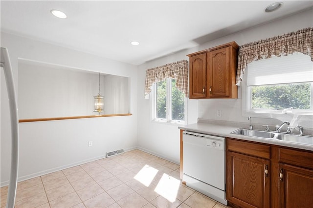kitchen with a wealth of natural light, dishwasher, a sink, and brown cabinets