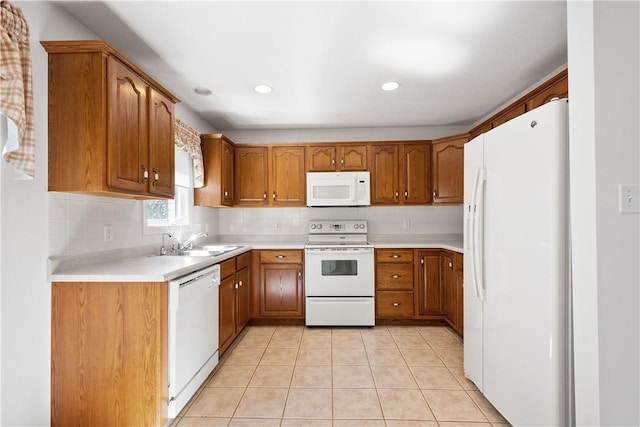 kitchen with a sink, decorative backsplash, white appliances, brown cabinetry, and light countertops