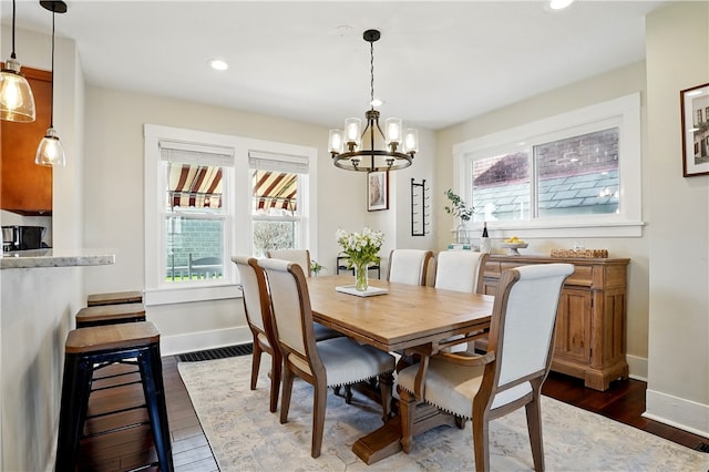 dining space with a notable chandelier, a wealth of natural light, baseboards, and dark wood-style flooring