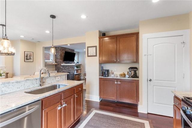 kitchen with dark wood-style flooring, light stone countertops, stainless steel appliances, and a sink