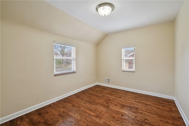 4203 Mckee Dr, Whitehall, PA 15236 - empty room featuring baseboards, lofted ceiling, dark wood-type flooring, and visible vents