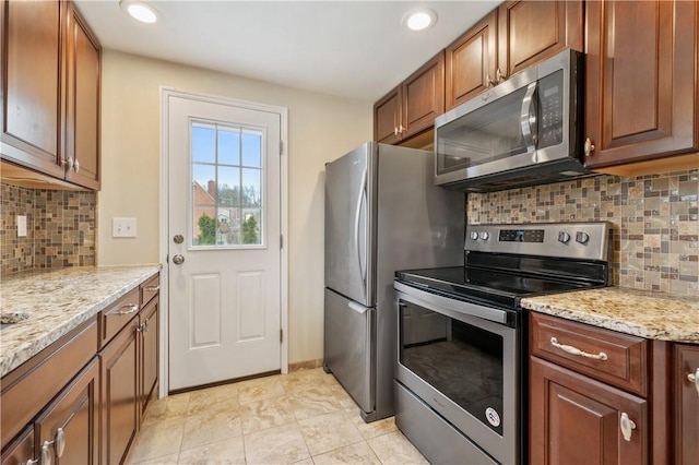 4203 Mckee Dr, Whitehall, PA 15236 - kitchen with brown cabinetry, decorative backsplash, light stone countertops, and stainless steel appliances
