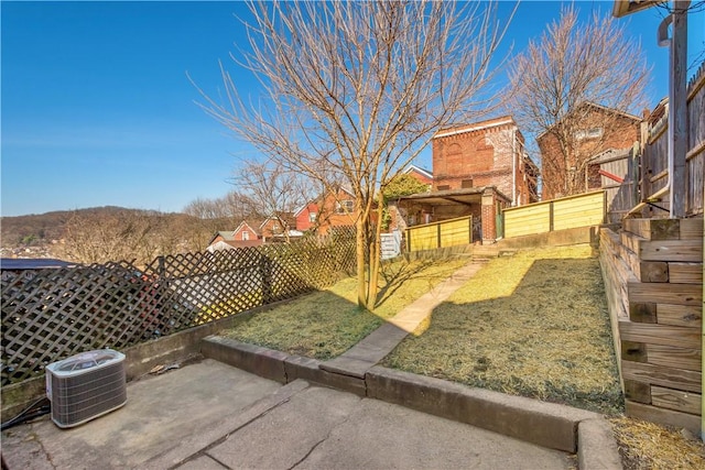 view of yard with central air condition unit, a patio area, and a fenced backyard