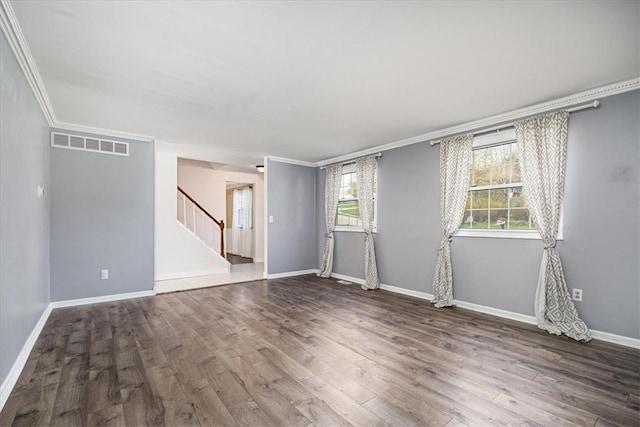 unfurnished room featuring stairway, visible vents, crown molding, and wood finished floors