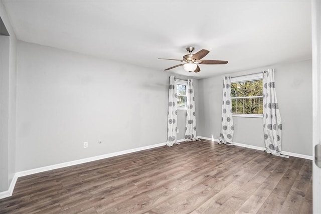 spare room with wood finished floors, baseboards, and ceiling fan