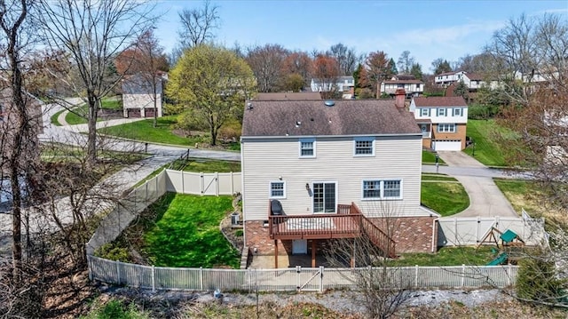 rear view of property with a gate, a fenced backyard, a yard, a wooden deck, and a residential view