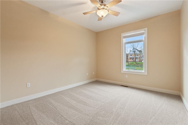 carpeted spare room featuring ceiling fan, baseboards, and visible vents
