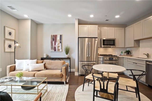 living area featuring baseboards, dark wood-style flooring, visible vents, and recessed lighting