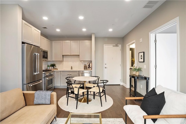 kitchen featuring a sink, dark wood finished floors, visible vents, recessed lighting, and high end appliances