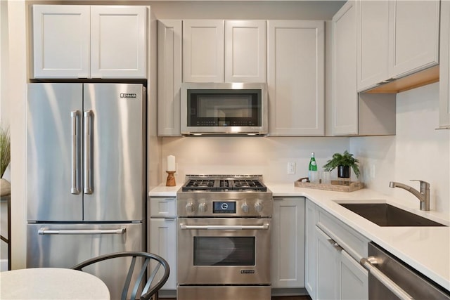 kitchen with stainless steel appliances, light countertops, and a sink