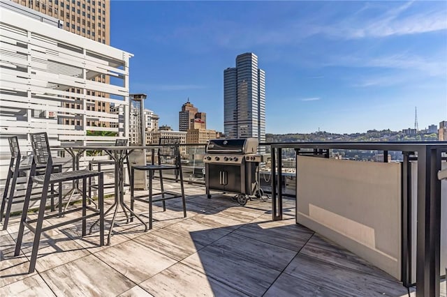 wooden deck with grilling area and a view of city