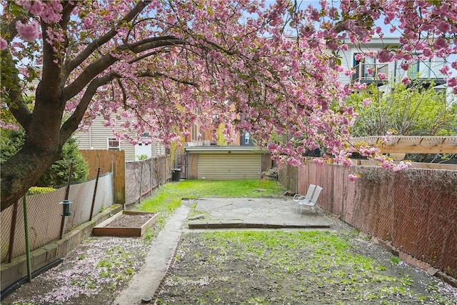 view of yard with a fenced backyard, an outbuilding, a patio area, and a vegetable garden