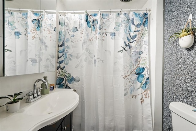 bathroom with curtained shower, toilet, and vanity
