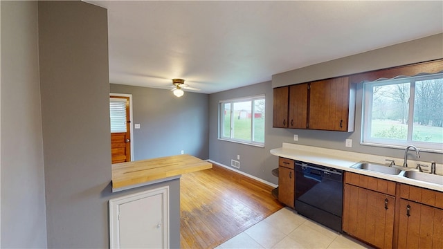 393 Eagle Mill Rd, Connoquenessing Twp, PA 16001 - kitchen featuring dishwasher, a sink, a ceiling fan, baseboards, and brown cabinetry
