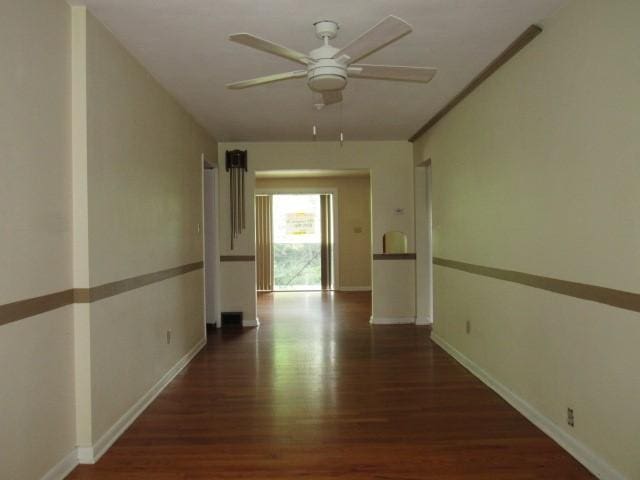 corridor with wood finished floors and baseboards