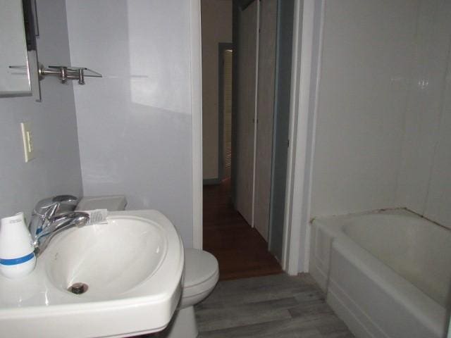 bathroom featuring a sink, wood finished floors, a bath, and a shower