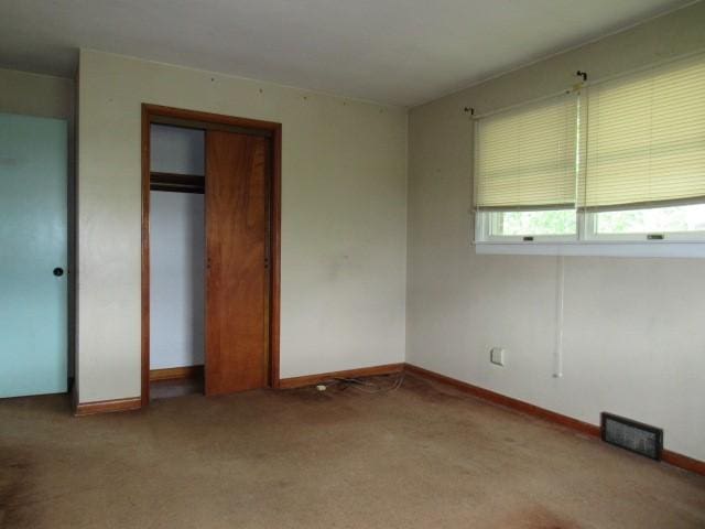 unfurnished bedroom featuring carpet flooring and baseboards