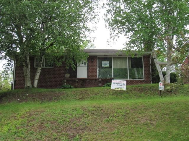 view of front of home with brick siding and a front yard