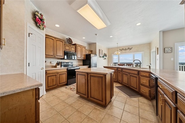 kitchen featuring light tile patterned floors, brown cabinetry, appliances with stainless steel finishes, and a healthy amount of sunlight