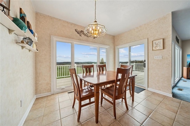 dining room featuring baseboards, a chandelier, and light tile patterned flooring