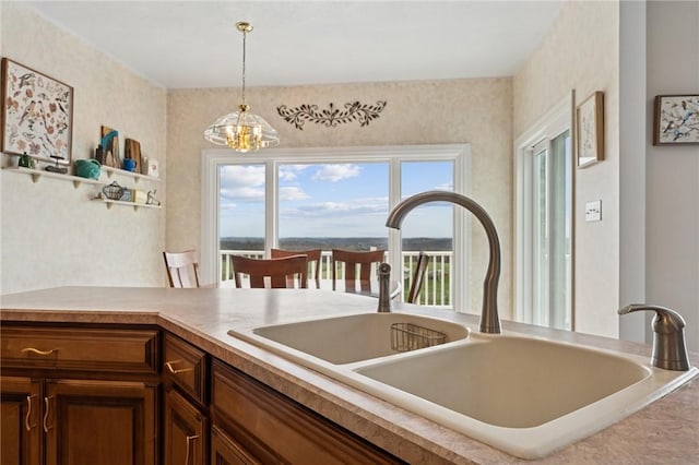 kitchen featuring an inviting chandelier, a sink, and pendant lighting