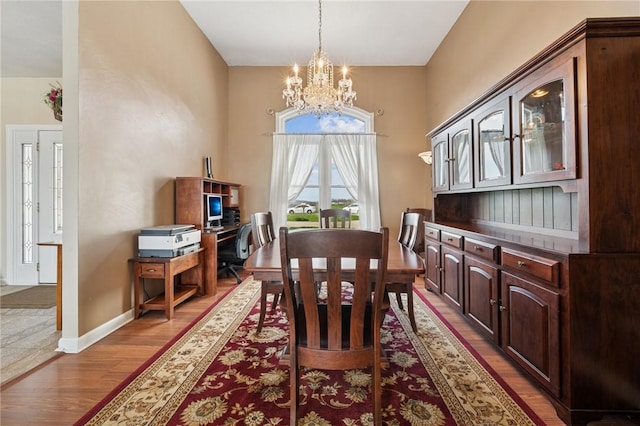 dining room featuring baseboards, a chandelier, and light wood-style flooring