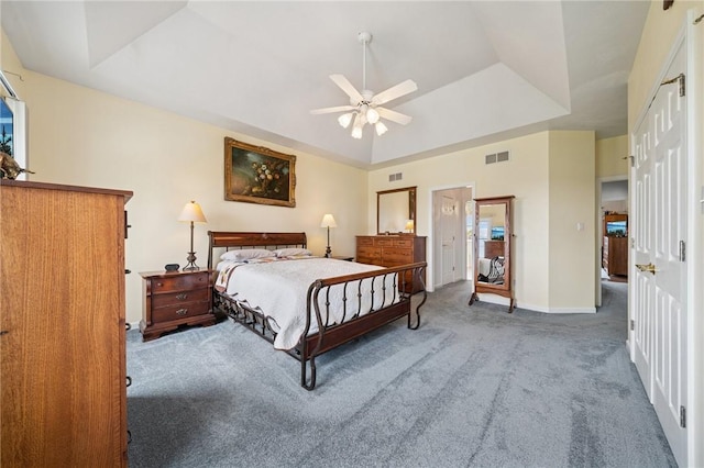 bedroom featuring visible vents, baseboards, carpet flooring, and a raised ceiling