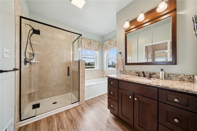 full bath featuring a stall shower, visible vents, wood finished floors, a garden tub, and vanity