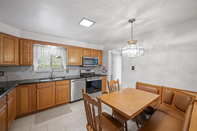 2314 Mcmonagle Ave, Banksville/Westwood, PA 15216 - kitchen featuring stainless steel appliances, dark countertops, a sink, decorative backsplash, and brown cabinetry