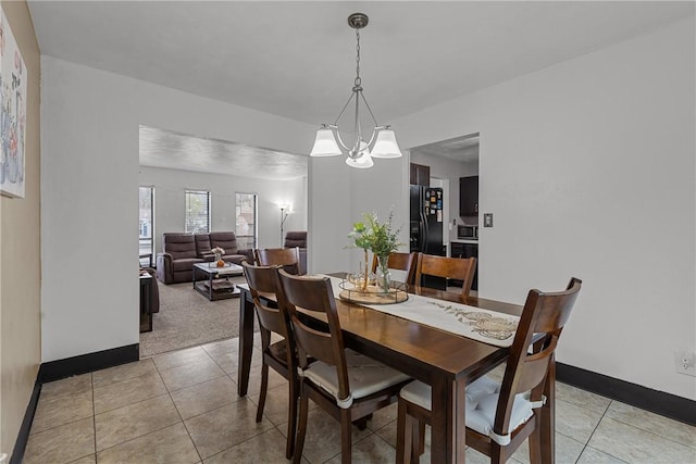 2240 Chapparal Dr, Plum Boro, PA 15239 - dining room with baseboards, light tile patterned flooring, and an inviting chandelier