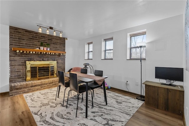 2240 Chapparal Dr, Plum Boro, PA 15239 - dining space with wood finished floors, baseboards, track lighting, and a brick fireplace
