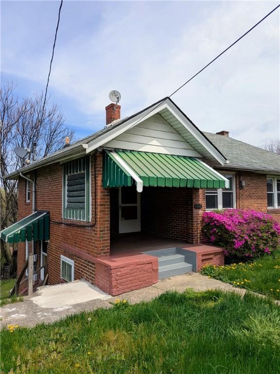 341 Ohio Ave, Clairton, PA 15025 - rear view of house featuring a standing seam roof, a chimney, and brick siding