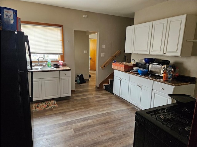 113 Ohio St, Stowe Twp, PA 15136 - kitchen featuring white cabinets, black appliances, light wood-style flooring, and a sink