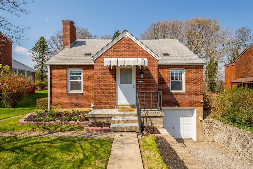 bungalow with a chimney, a front lawn, driveway, a garage, and brick siding