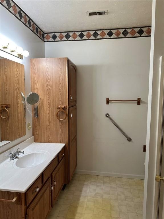 bathroom with baseboards, vanity, and tile patterned floors