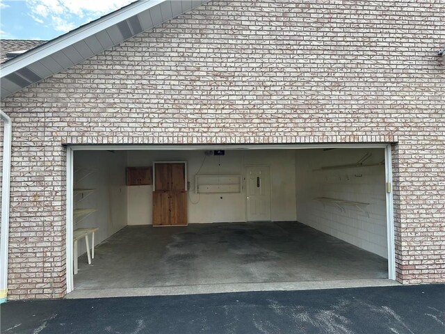 garage featuring asphalt driveway