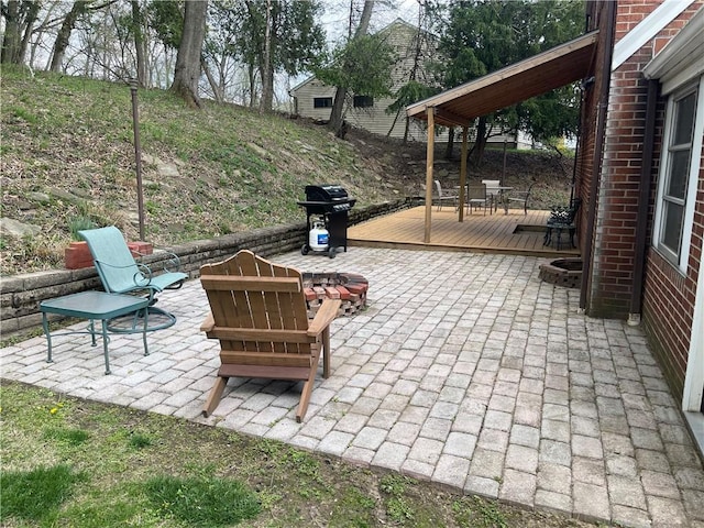 view of patio with a fire pit, a grill, and a deck