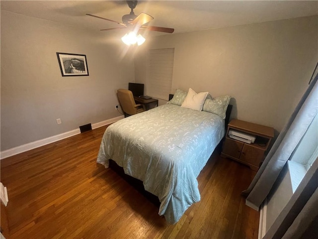 bedroom featuring ceiling fan, baseboards, and wood finished floors