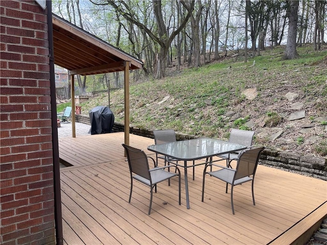 deck featuring outdoor dining area and a grill