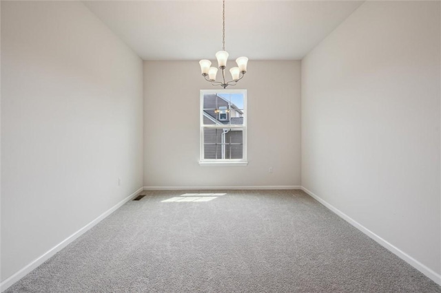 empty room featuring baseboards, carpet, and a chandelier