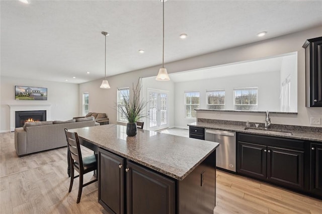 kitchen featuring dishwasher, a healthy amount of sunlight, open floor plan, and a sink