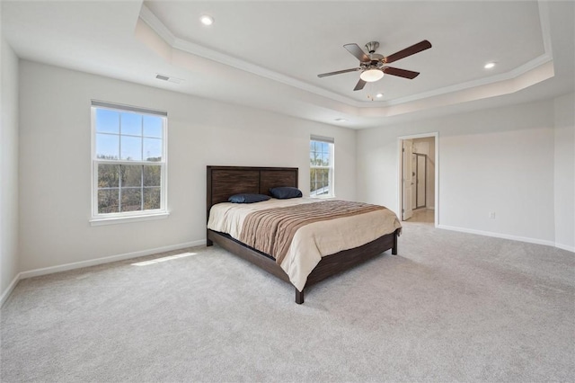 bedroom featuring ornamental molding, baseboards, visible vents, and a raised ceiling