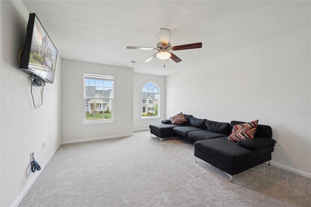 living room featuring carpet floors, visible vents, baseboards, and ceiling fan