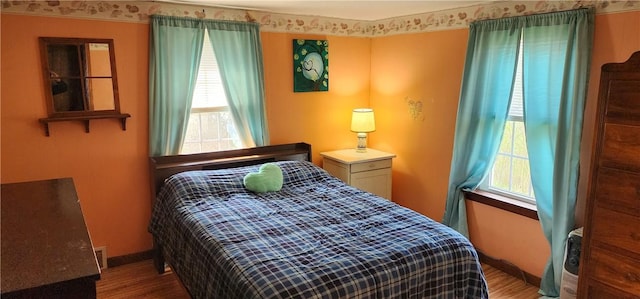 bedroom featuring wood finished floors and baseboards