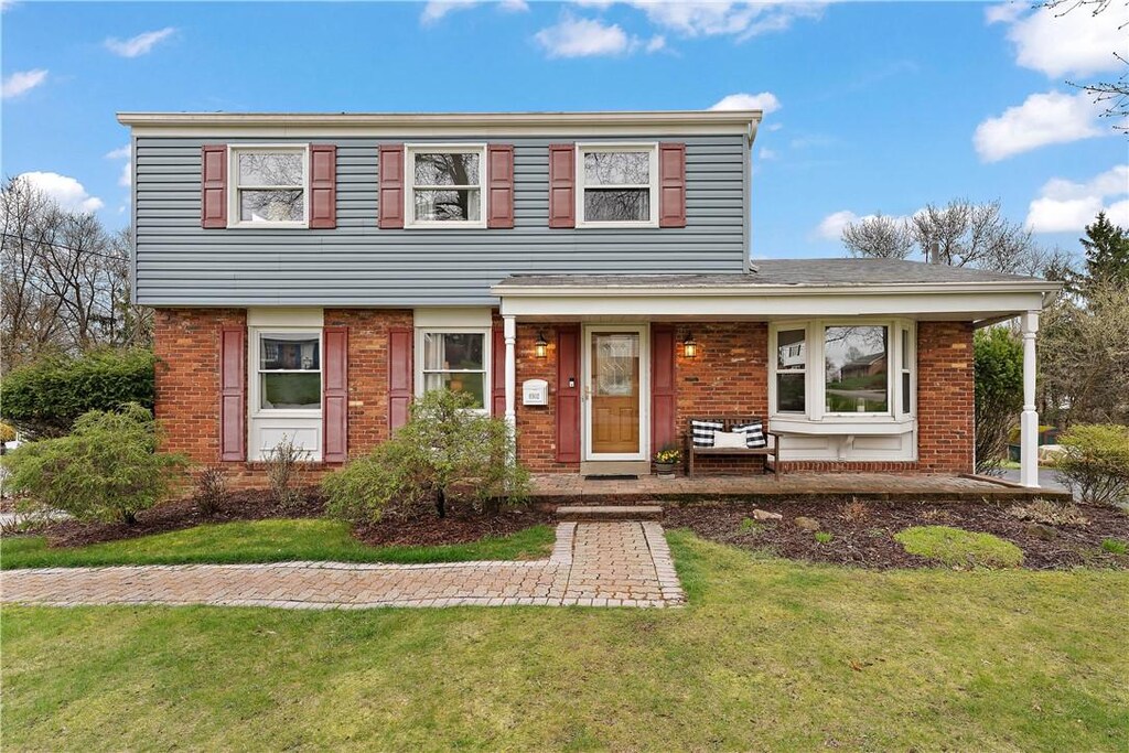 8502 Ridgemont Rd, Mccandless, PA 15237 - view of front facade with a porch, brick siding, and a front yard