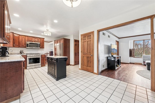 kitchen featuring stainless steel appliances, light stone counters, recessed lighting, and light tile patterned floors