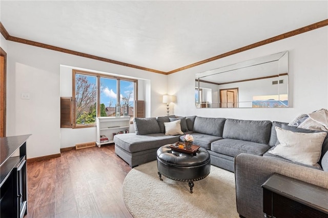 living area featuring wood finished floors, visible vents, baseboards, and ornamental molding