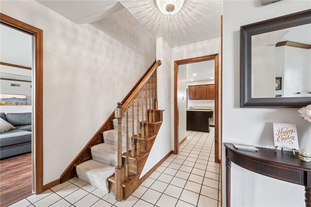 stairway featuring tile patterned floors and baseboards