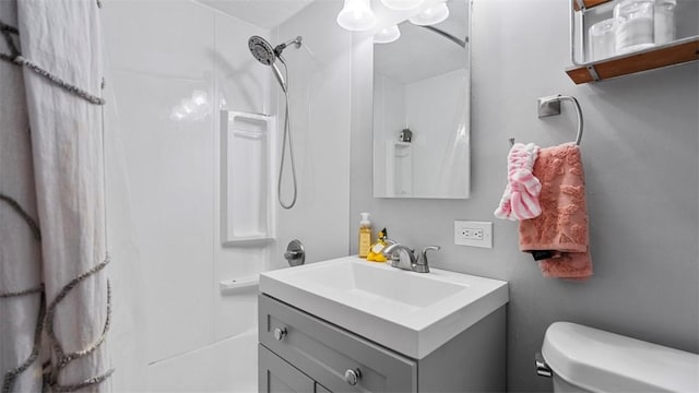 full bathroom with toilet, vanity, and a shower
